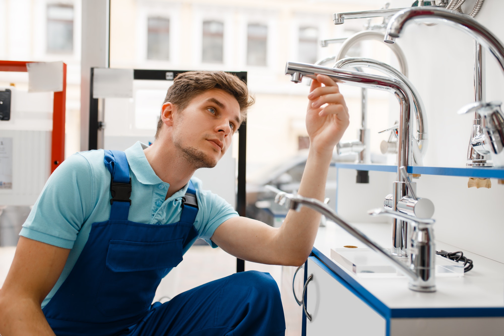 Plumber in uniform at showcase in plumbering store